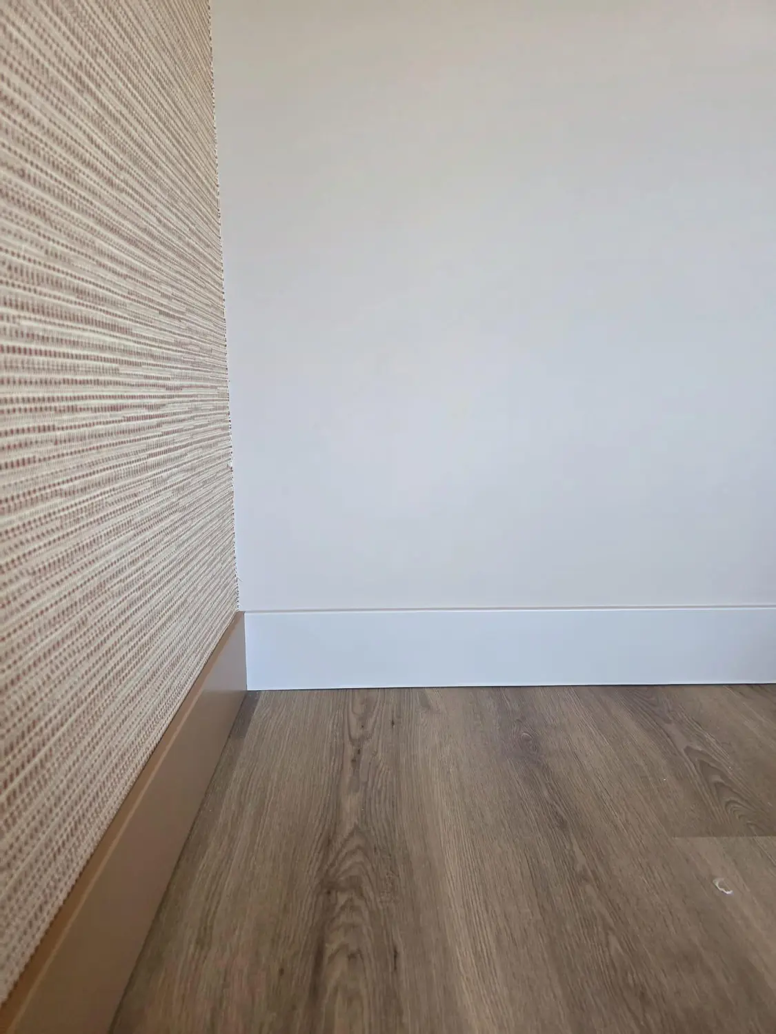 Witte profielplint langs parket en een groene wand, detail 1