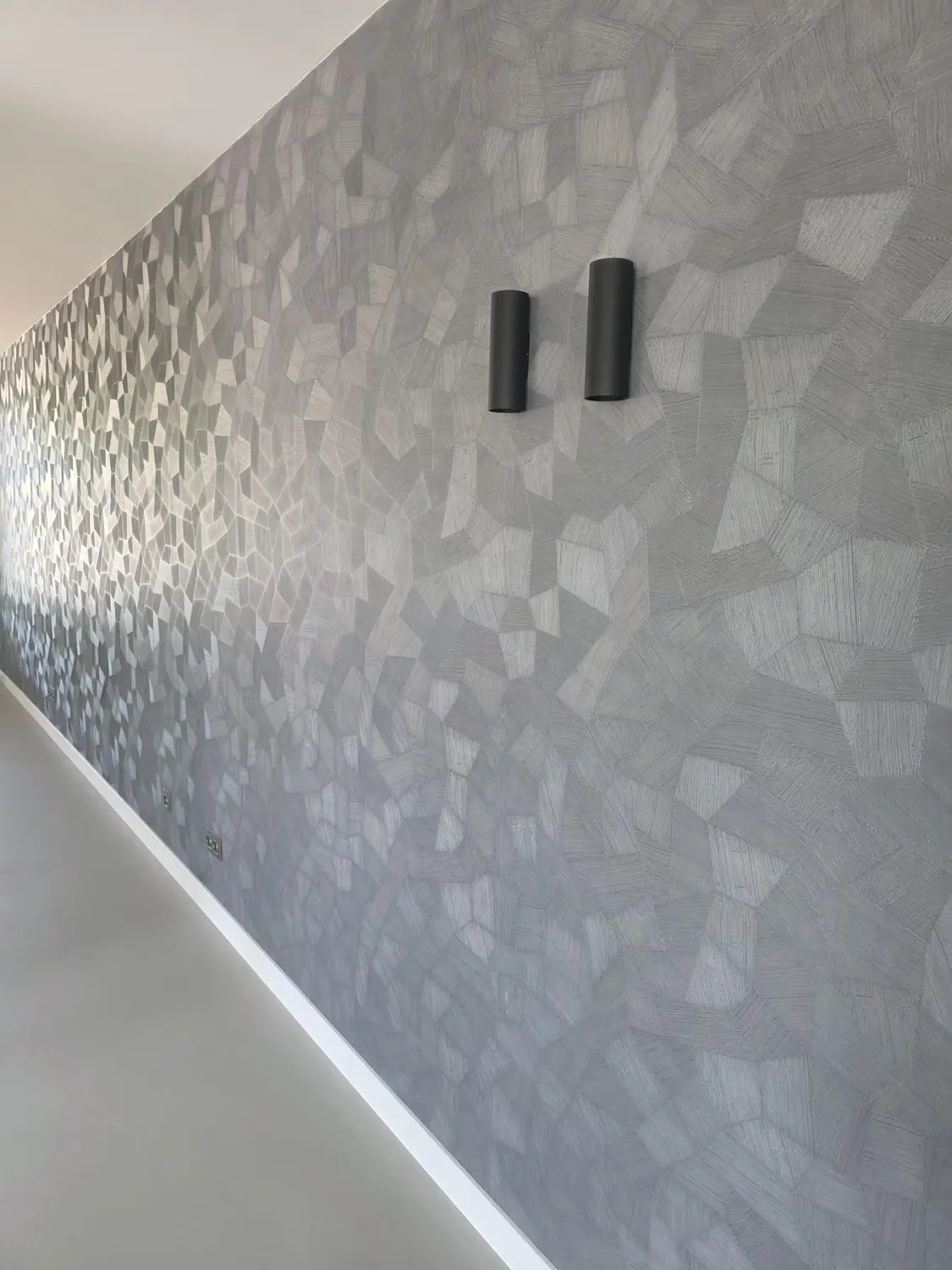 Hoge witte plint onder een grafische behangwand, detail 1